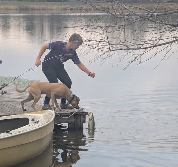 A boy with his dog fishing.